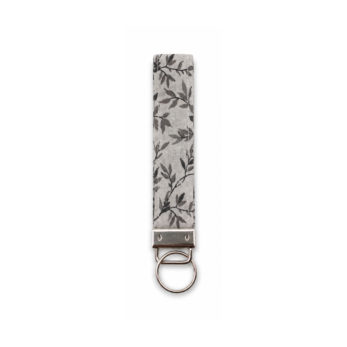 Gray fabric keychain with dark vine leaf pattern and metal ring attachment.
