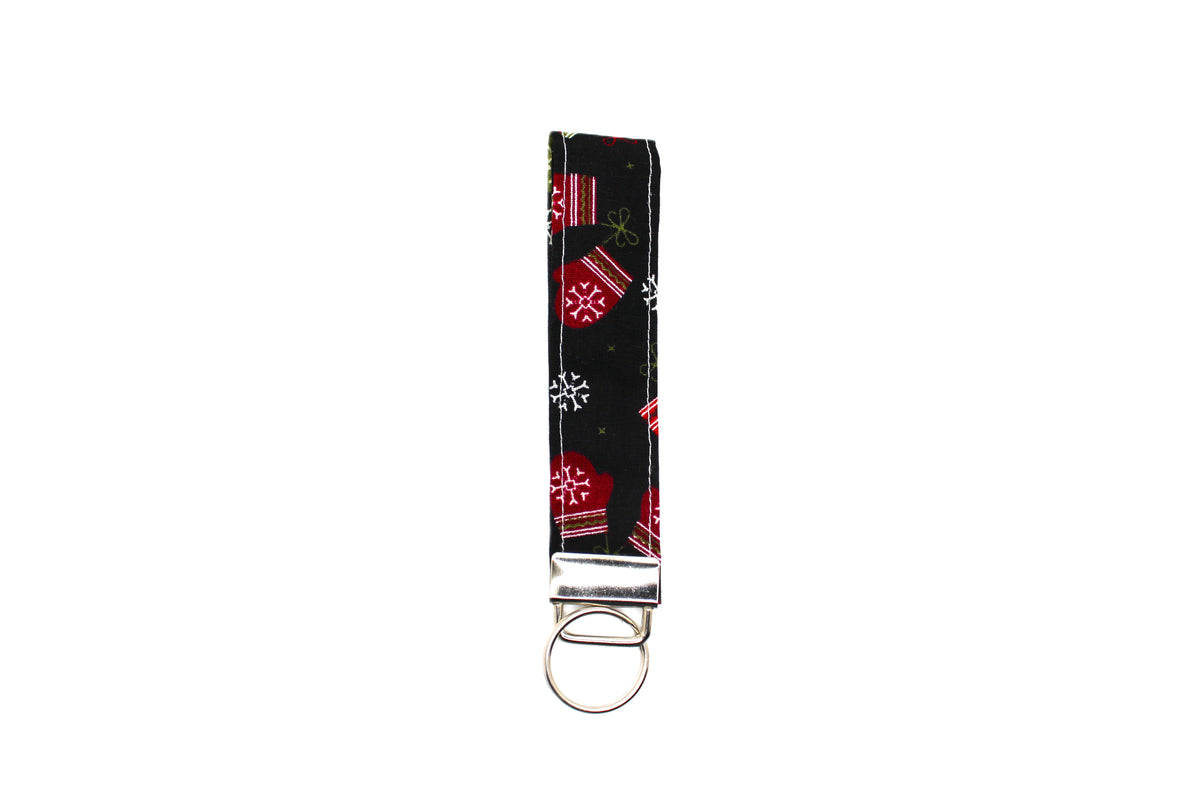 Black Snow Paws keychain strap featuring red and white snowflakes, finished with a silver metal split ring.