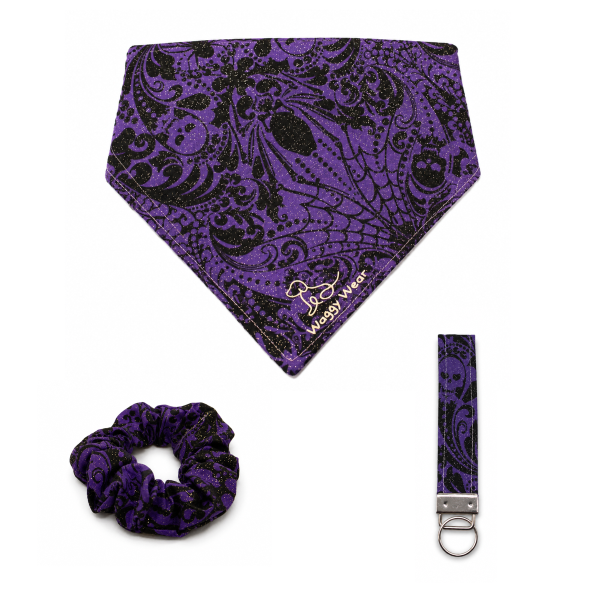 Purple and black paisley dog bandana, scrunchie, and leash clip from the Waggy Wear Haunted Howl Bundle.