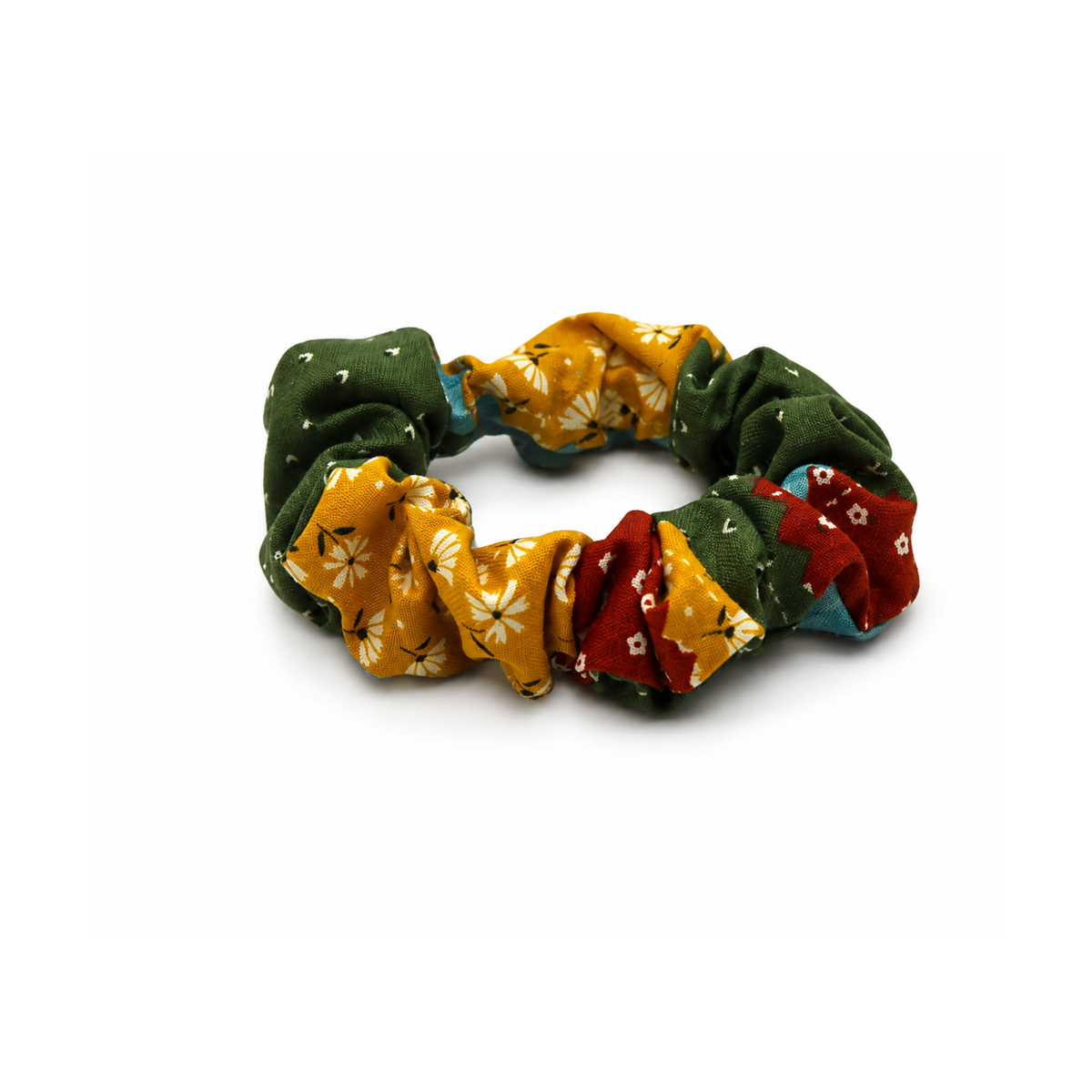 Multicolor floral fabric scrunchie in green, yellow, and red with white daisy patterns.