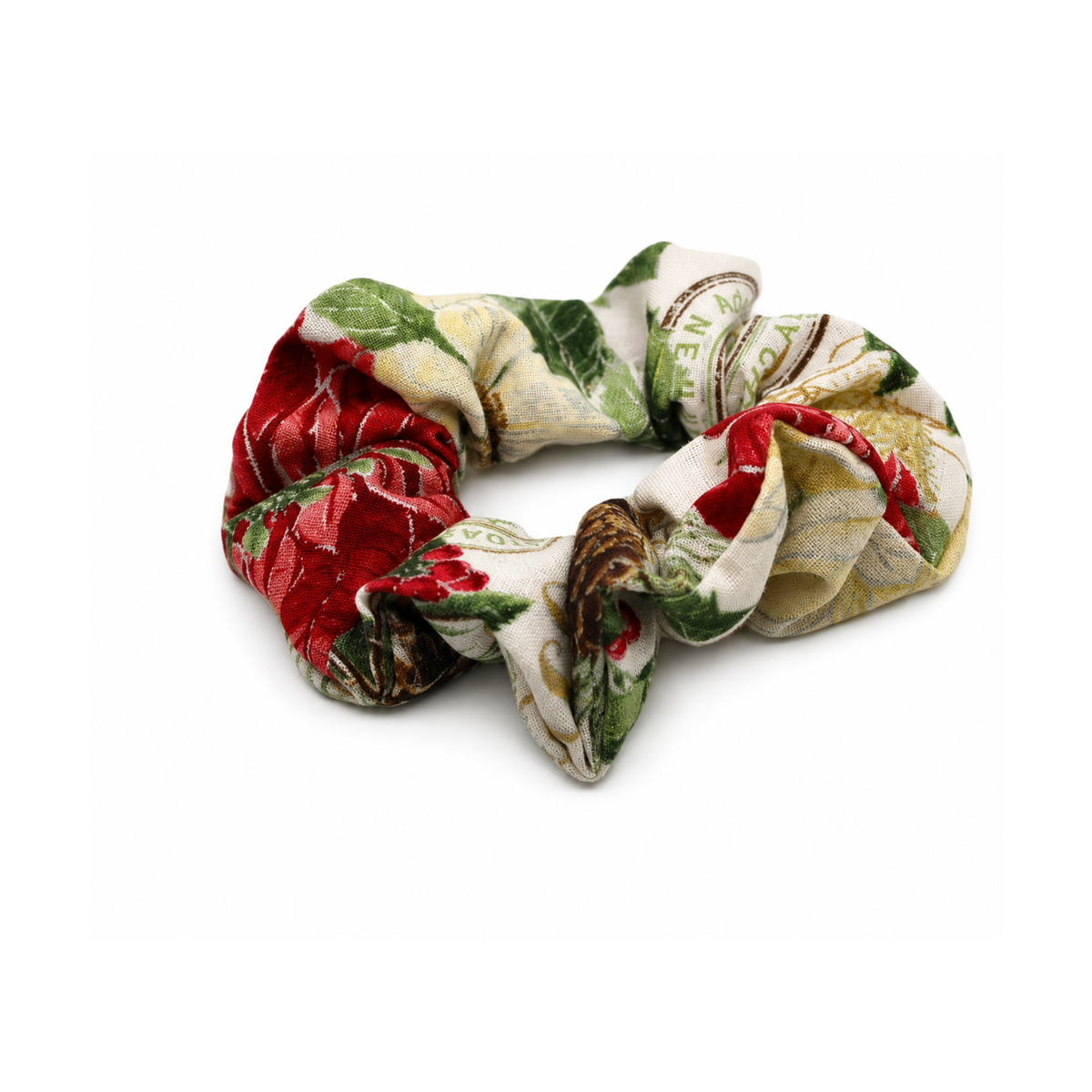 Red, green, and cream floral fabric hair scrunchie with Mistletoe & Magic branding.
