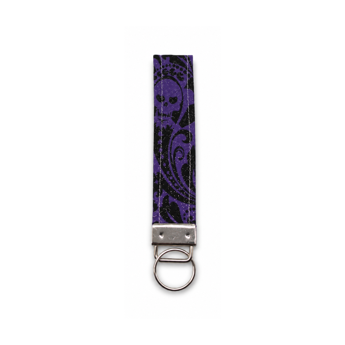 Purple and black gothic skull patterned fabric strap with metal clasp and ring, The Haunted Howl Keychain.